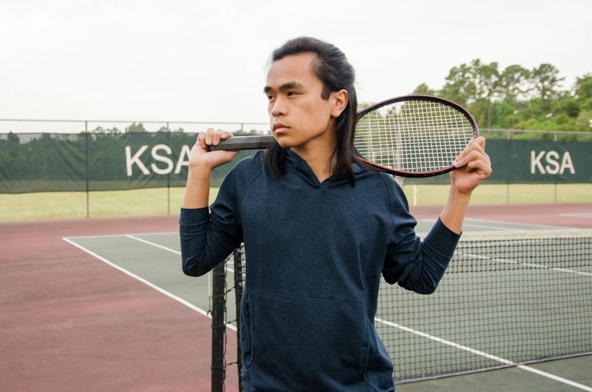 Model Wearing Public Rec Politan Hoodie And Standing Holding Tennis Racquet On Shoulder