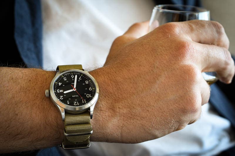 model wearing vaer c5 heritage field watch holding glass