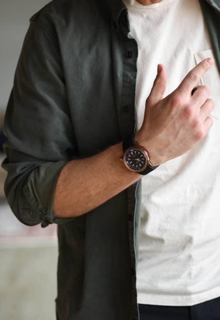 model wearing vincero vessel dive watch with green and white shirt