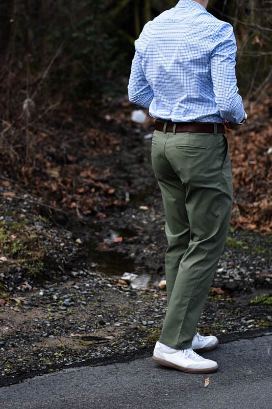 model with back turned to photographer wearing green chinos and blue dress shirt