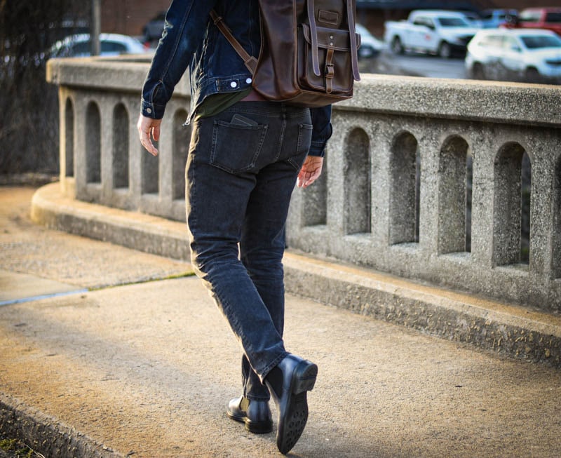 model with leather rolltop backpack and ice blue lawry chelsea boots from Moral Code