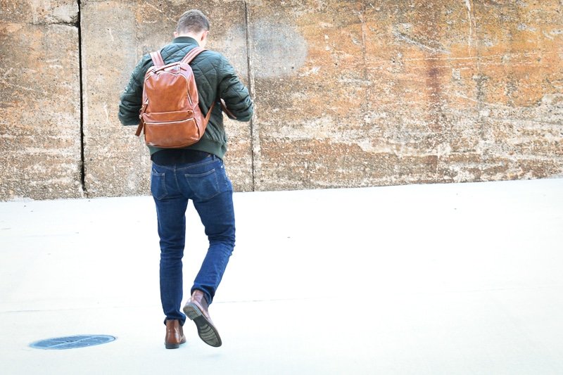 modern made man leather backpack walking away
