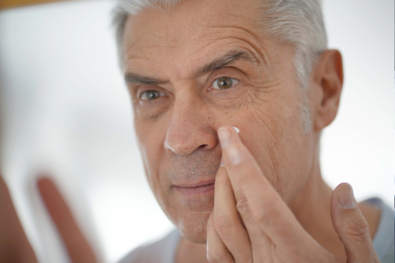 older man using skin care