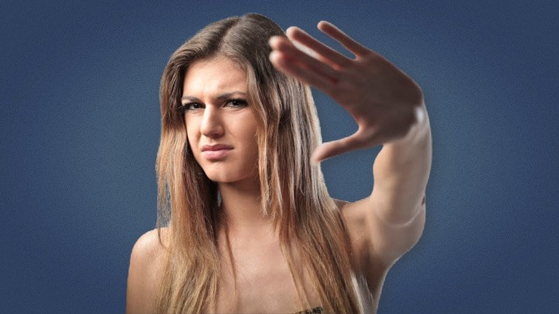 Pretty girl putting up her hand in rejection on plain background 1