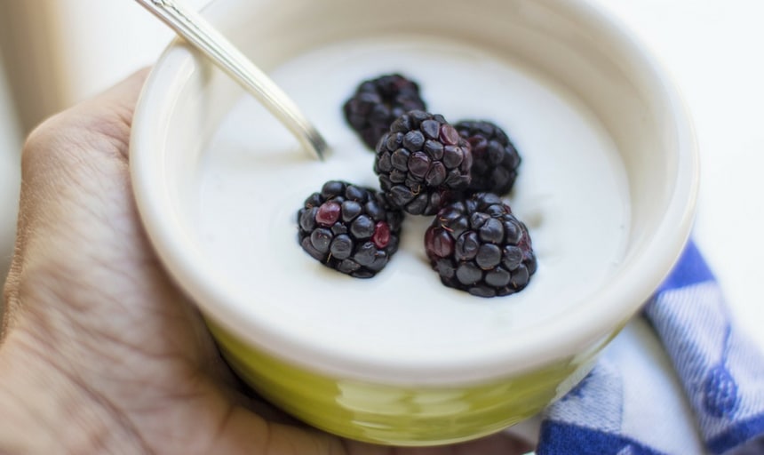 Yoghurt with berries being held in the air