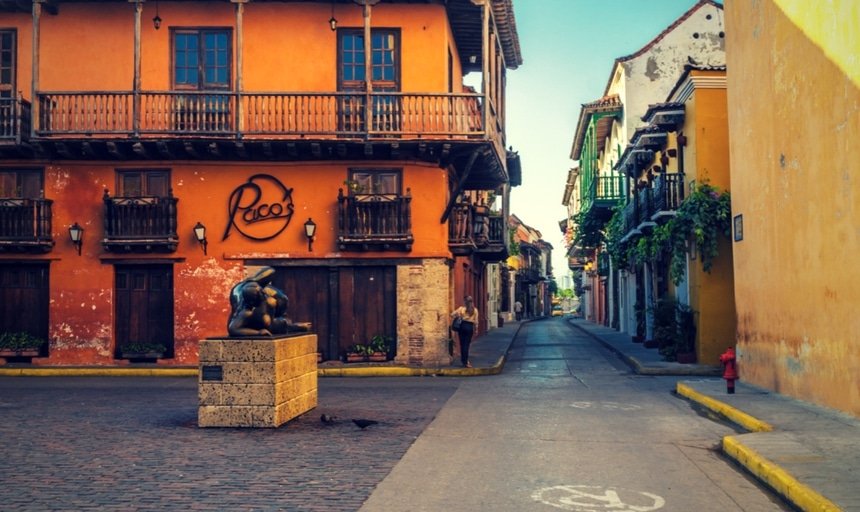 Streets of Cartagena, Colombia in the daytime with woman walking down the street, near Paco's