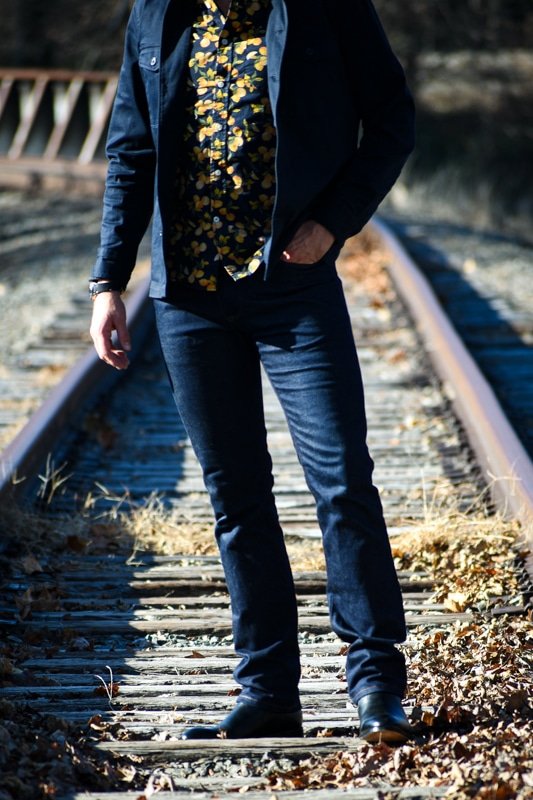 torso and legs of model wearing dark blue jeans with dark blue outfit