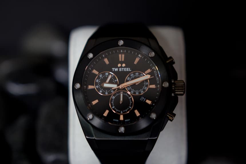 TW Steel CEO Tech watch propped up against black stones on black background c
