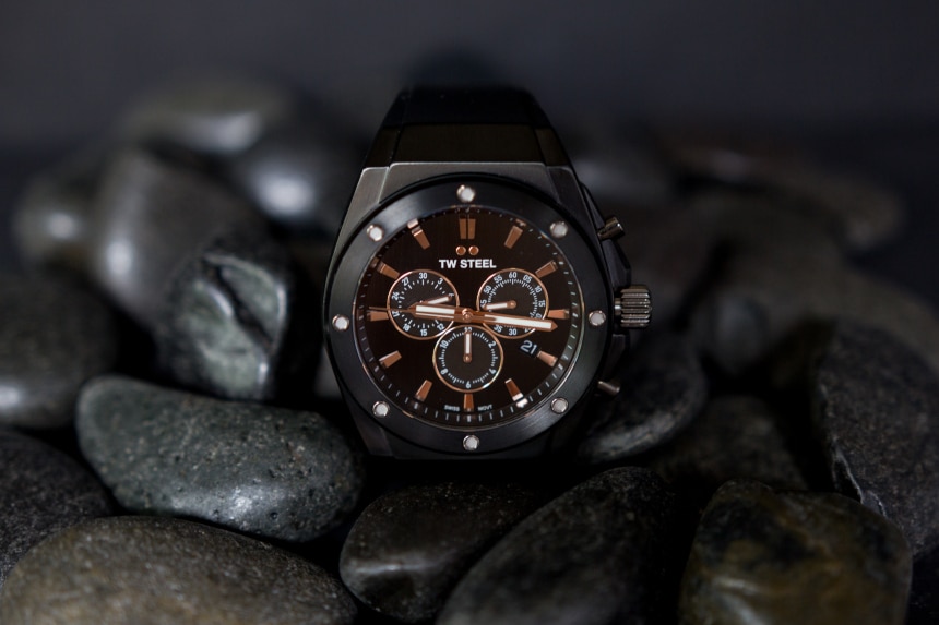 TW Steel CEO Tech watch propped up against black stones on black background e