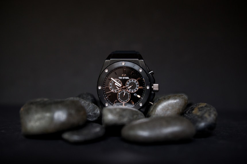 TW Steel CEO Tech watch propped up against black stones on black background f
