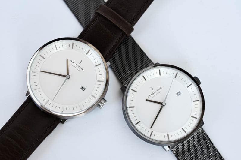 two nordgreen philosopher watches leather band steel mesh band overlap on white background