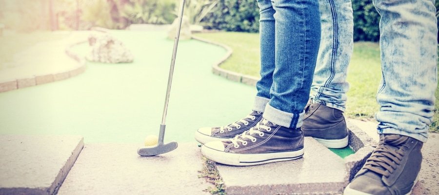 Couple playing minigolf