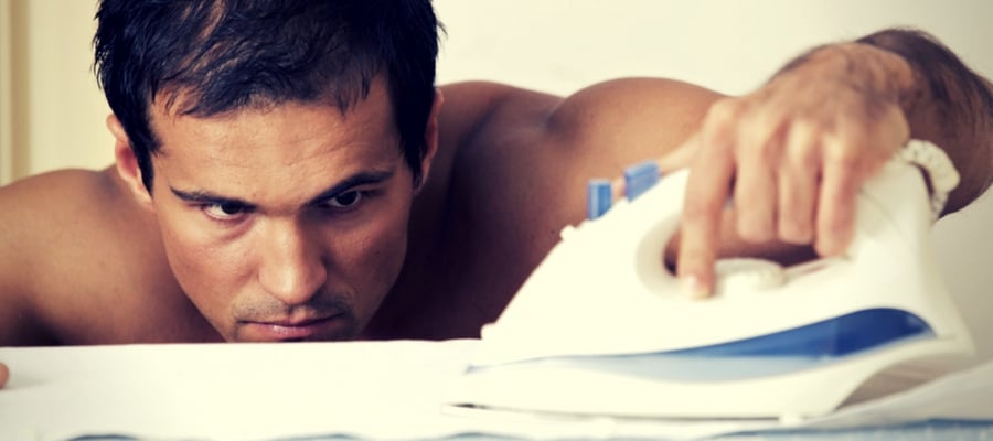 Man concentrating on ironing without a shirt on