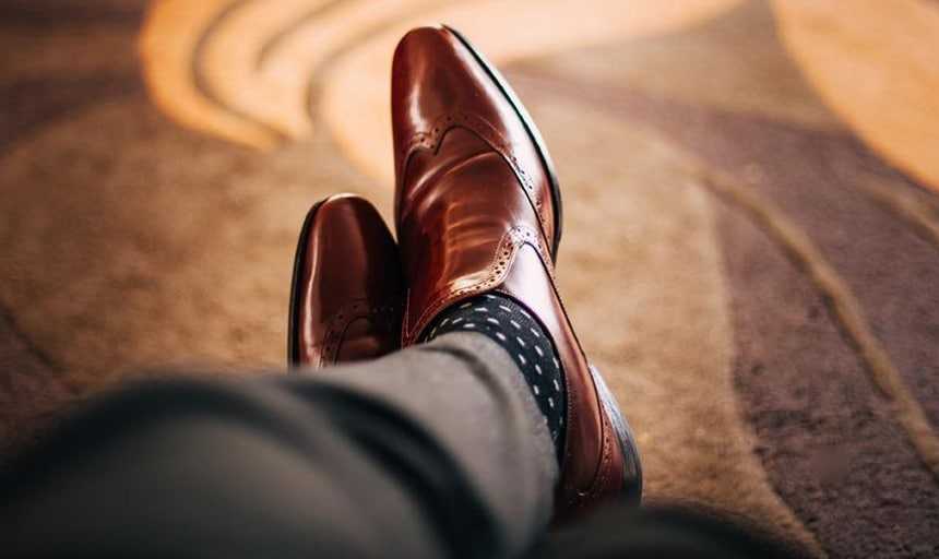 View from above of brown leather dress shoes and polka dot socks