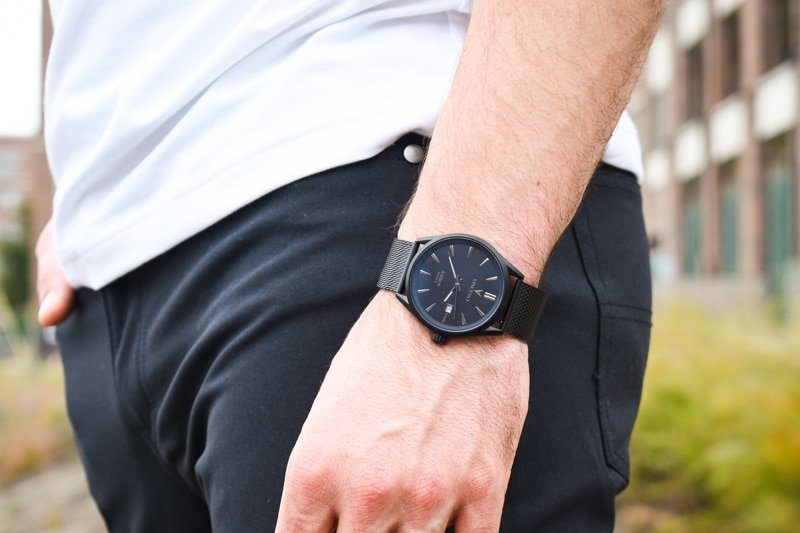 Vincero Kairos black on wrist with model wearing white t shirt and jeans